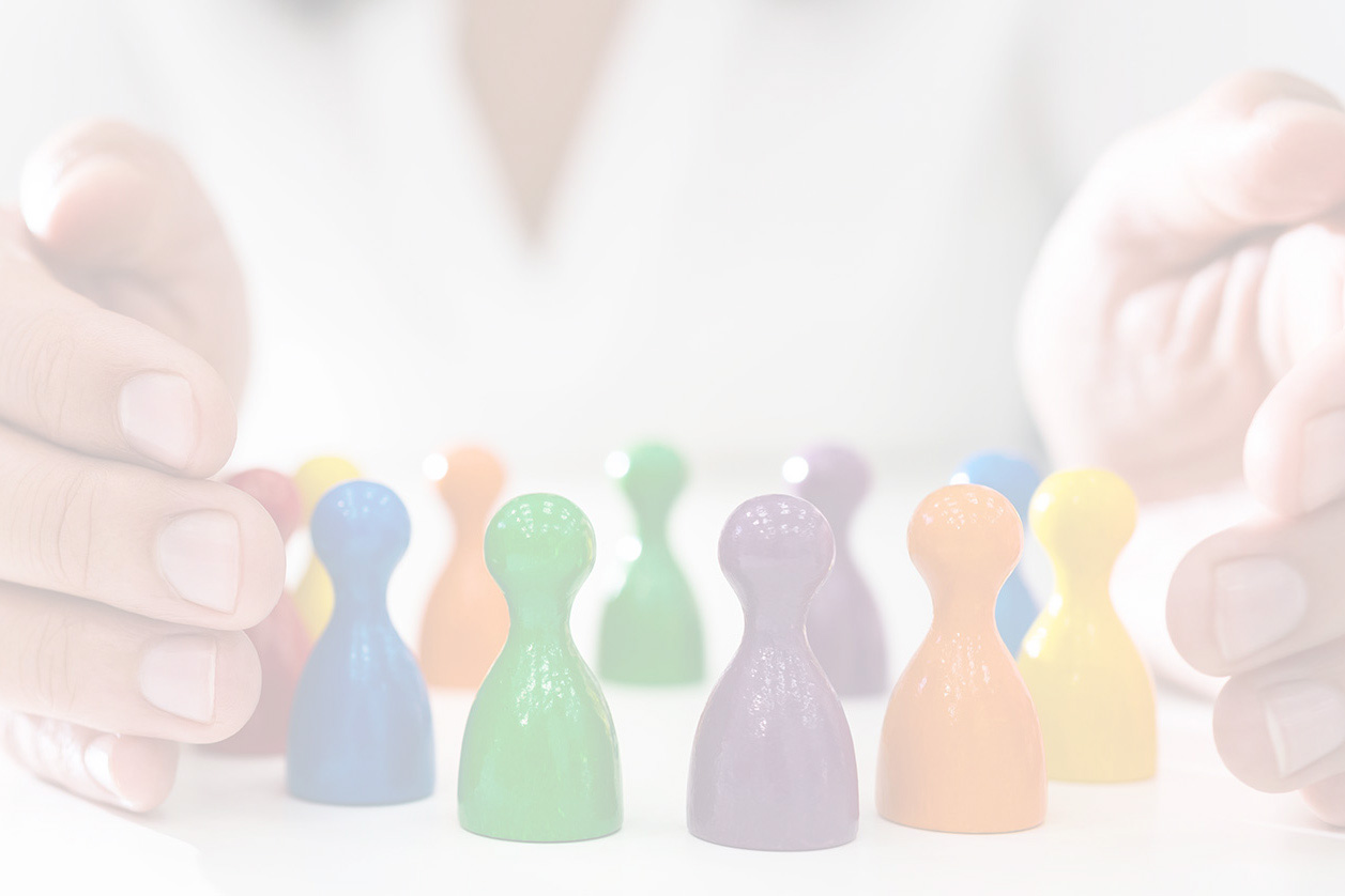 A collection of miniature humainoid figures in diverse colors, protected by human hands, representing the promotion and conservation of diversity.