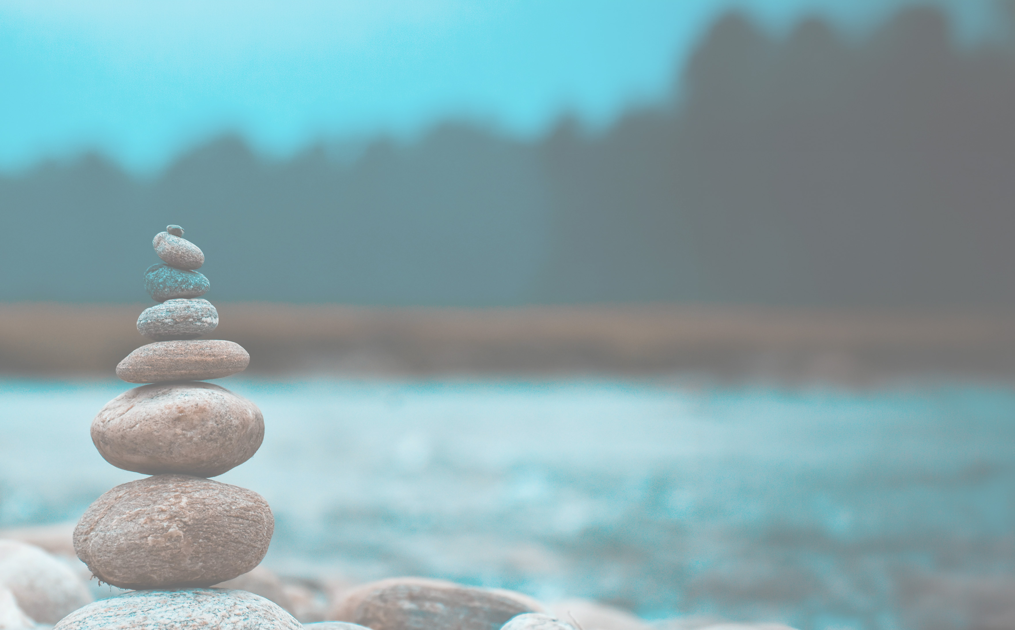 A peaceful zen style stack of rocks next to a body of water