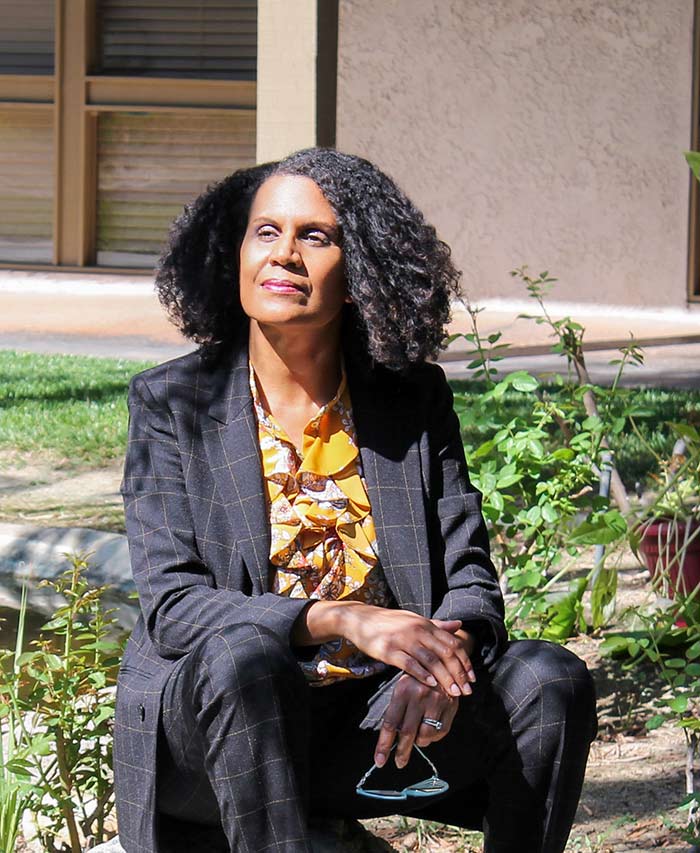 Dr. Lori Barker sitting peacefully in a garden.